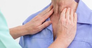 a nurse feeling a patient's throat for a swollen thyroid