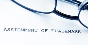 a paper titled assignment of trademark with a pair of glasses lying on top of it