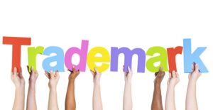 multiple individual arms holding up individual letters spelling out the word trademark