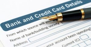 a form requesting bank and credit card details with a pen lying on top of it