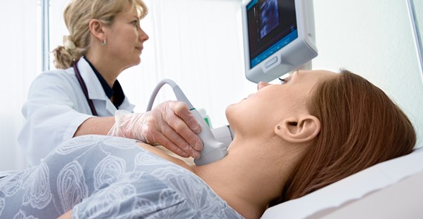 a doctor examines a patient for signs of hyperthyroidism