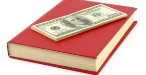 an image of money and a law textbook that will both be used for a juris doctor degree