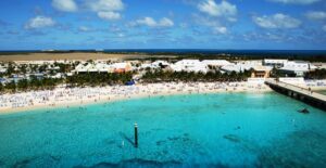 an overview of the beach and ocean with people sunbathing and swimming