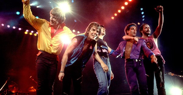 the band Journey stands on stage