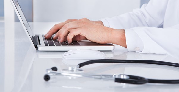 an aspiring medical assistant studying with a laptop