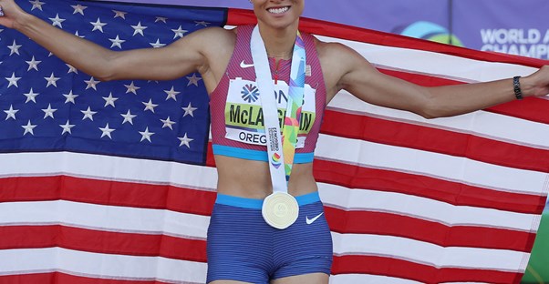 Sydney McLauglin-Levrone holding an american flag and showing off her olympic medal