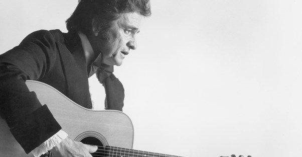 a black and white image of johnny cash playing his guitar from a profile view