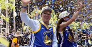 joe lacob waves at the crowd during a parade