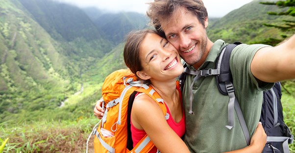 a couple takes a selfie picture over a moutain valley