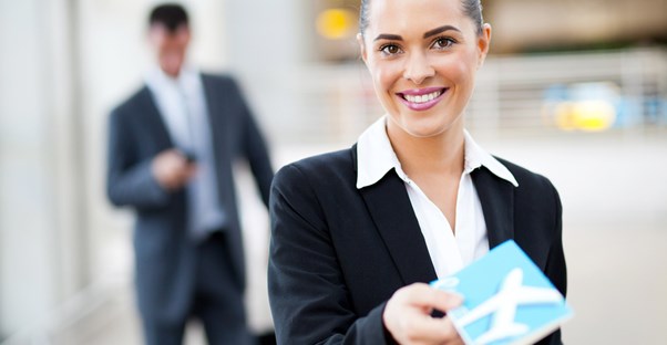 a flight attendant hands the viewer a business class boarding pass