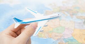 a person holding a model airplane over a map of North Africa