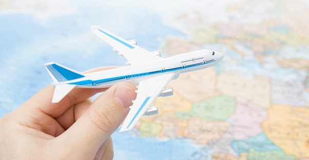 a person holding a model airplane over a map of North Africa