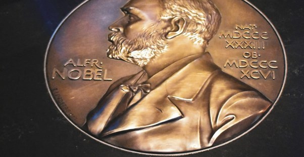 a nobel prize medal sitting on a black table top