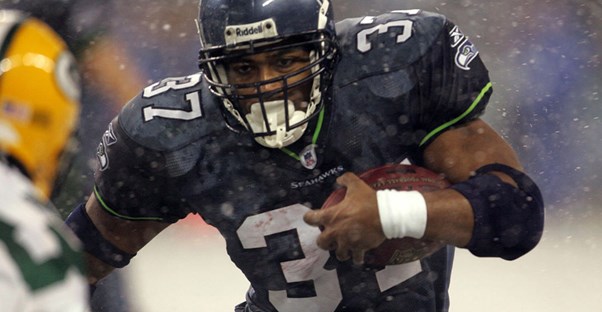 Shaun Alexander busting through a defensive line during an NFL game