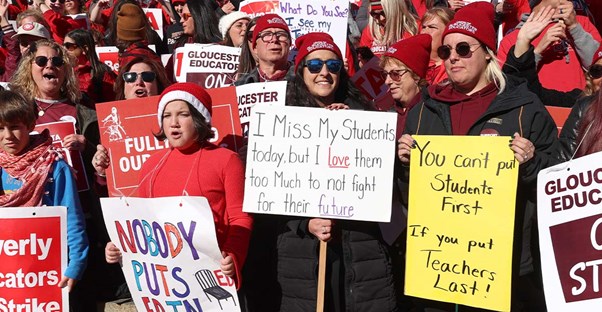 teachers protesting wearing red and holding signs