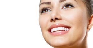 Woman smiling at her reflection after a 5-minute makeup routine
