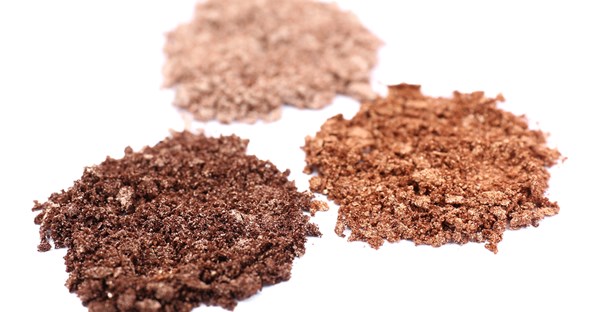 Three piles of crushed makeup containing ingredients you should avoid