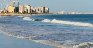 a beachside view of myrtle beach complete with high-rise hotels and a ferris wheel
