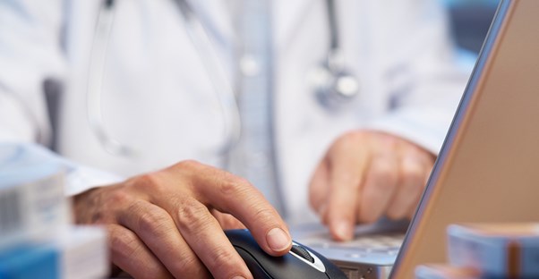 Pharmacy technician works on a computer