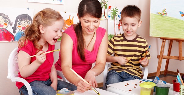 a babysitter and 2 children spend time painting