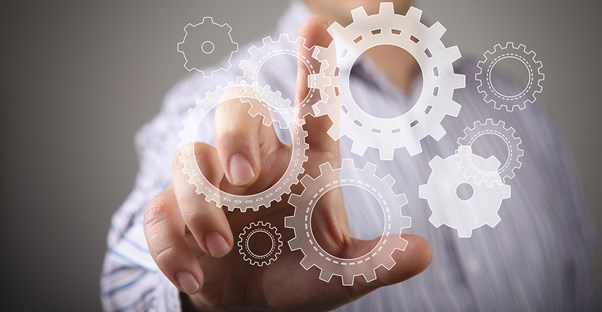 Man pointing to an image of gears as he decides if he should be a mechanical engineer