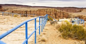 a railed lookout point at the edge of the southern rim of the grand canyon