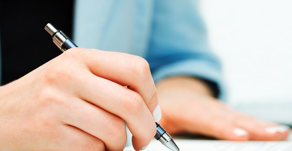 Woman signing a contract with a lawyer for help with workers compensation claims