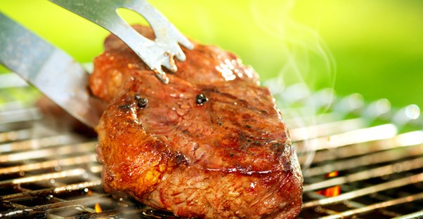 a tasty piece of meat being turned on the grill