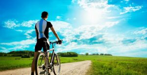 Man biking down a gravel road to reduce his use of gas