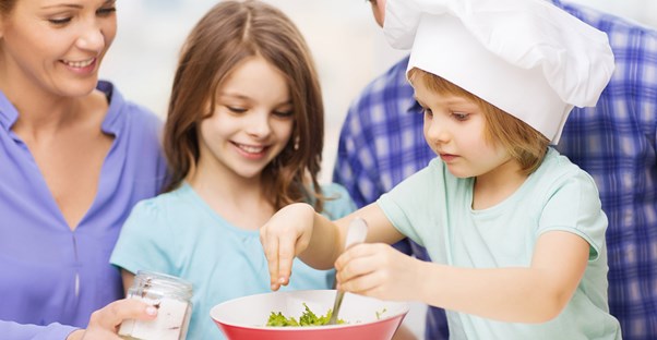 a young couple baking with their daughters