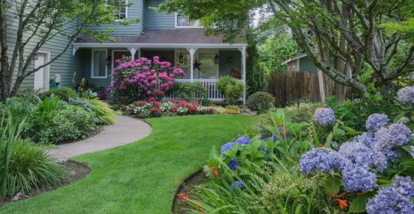 a green lawn leads to the front door of a house