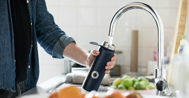 refilling a refillable bottle at the sink that may have forever chemicals