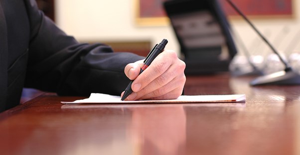 Man signing an index fund agreement after choosing the right kind of index fund for him.