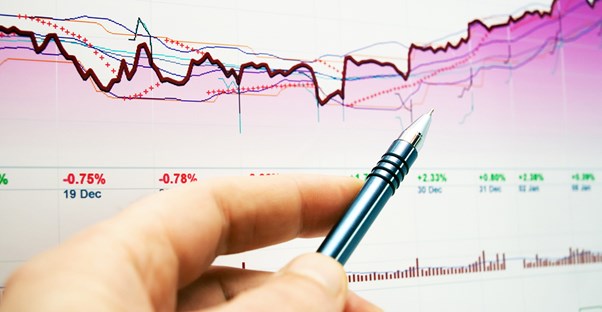 Close up of a man studying an index fund chart to decide if he should invest in index funds.