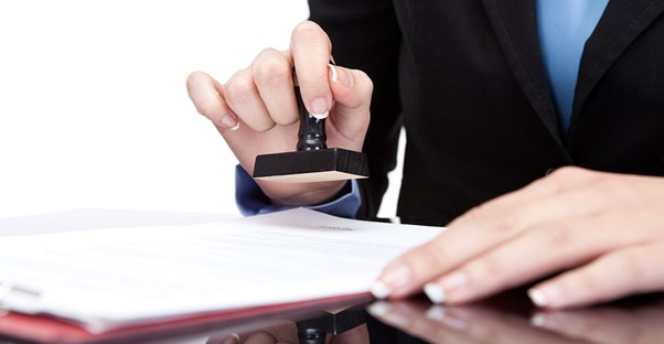 Woman stamping a certificate of deposit agreement after explaining the interest rate.