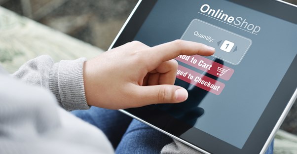 A man finishing an e-commerce transaction on a tablet to demonstrate how e-commerce impacts our lives.