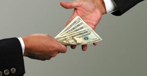 A lender handing cash to the borrower of a guarantor loan.