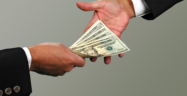A lender handing cash to the borrower of a guarantor loan.