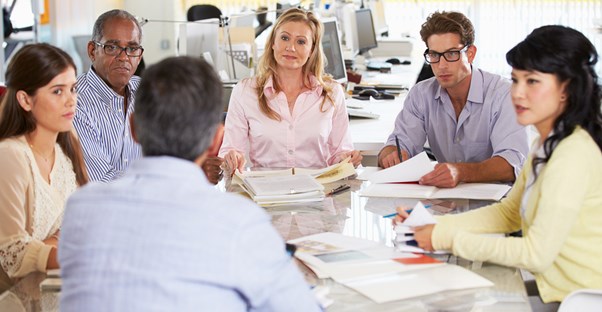 A group of graphic designers sit at a round table to discuss the common misconceptions related to graphic design.