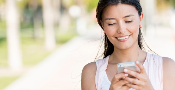 a woman messages a potential match via her cell phone to set up a date