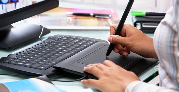 A female graphic designer works on a graphic design program after graduating from one of the best graphic design schools.
