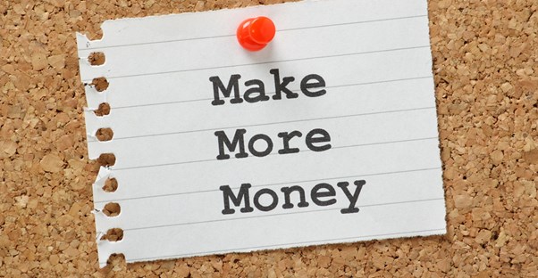 A piece of lined paper reading Make More Money pinned to a bulletin board to represent the importance of saving money for your future.
