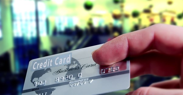 A hand throwing away a credit card after deciding to consolidate credit cards.