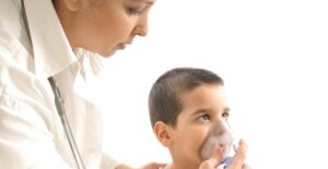 a respiratory therapist gives a young patient an exam