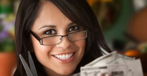 Woman smiling as she clips coupons like a normal person.