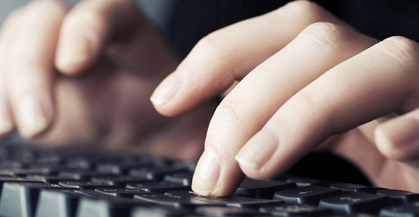 a medical transcriptionist types on a keyboard