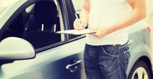 a car rental worker inspects a newly returned car