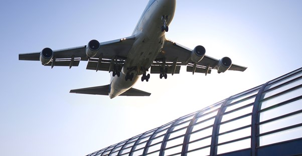 a airplane flies over an air terminal
