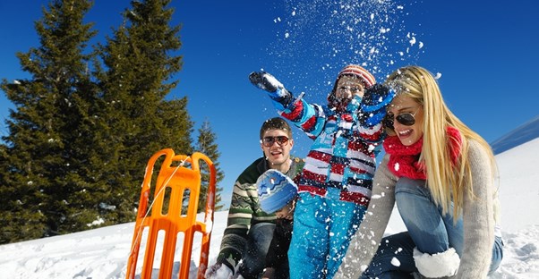 a family frolics in the snow on their vacation
