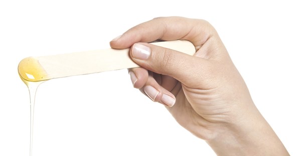 a woman prepares for the pain of waxing her eyebrows